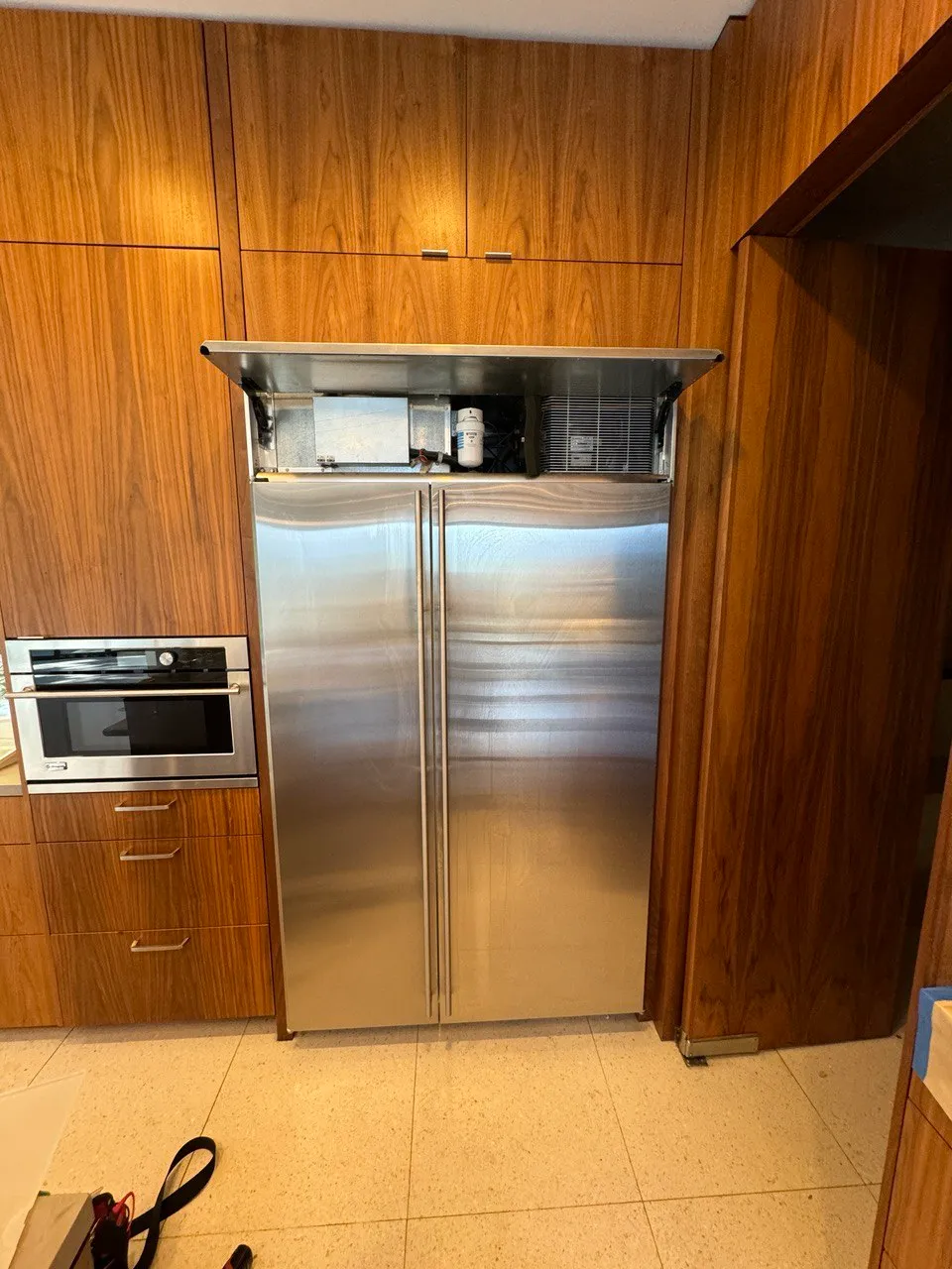 Stainless side-by-side refrigerator in a walnut kitchen