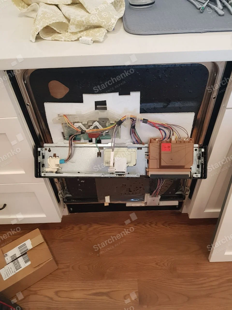 Samsung repair: Built-in dishwasher door with outer panel removed, exposing detergent dispenser and wiring.