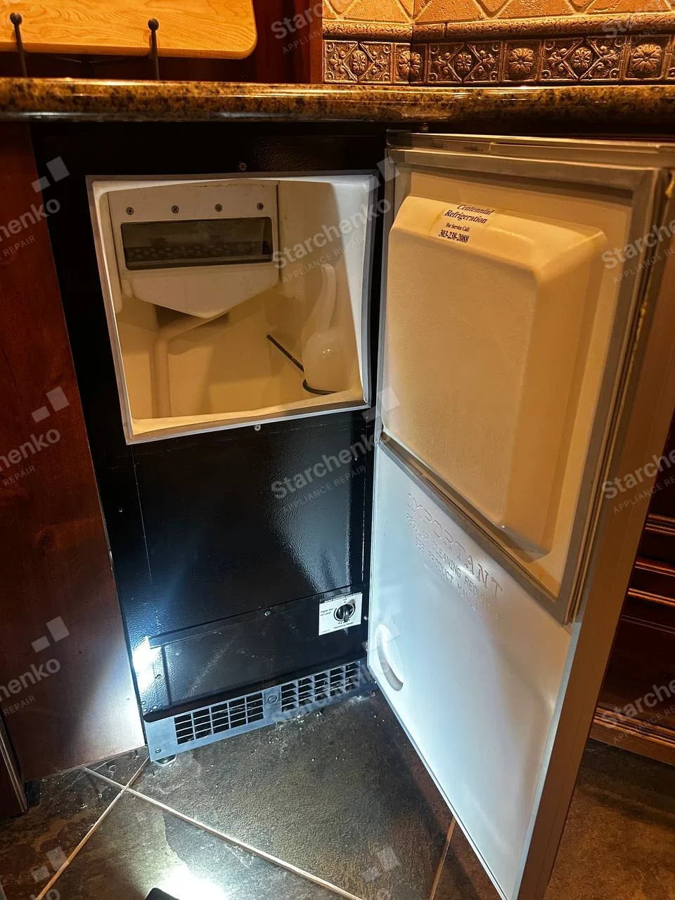 Scotsman Ice Systems lettering molded on inner door of built-in undercounter ice machine, service-company sticker is separate.