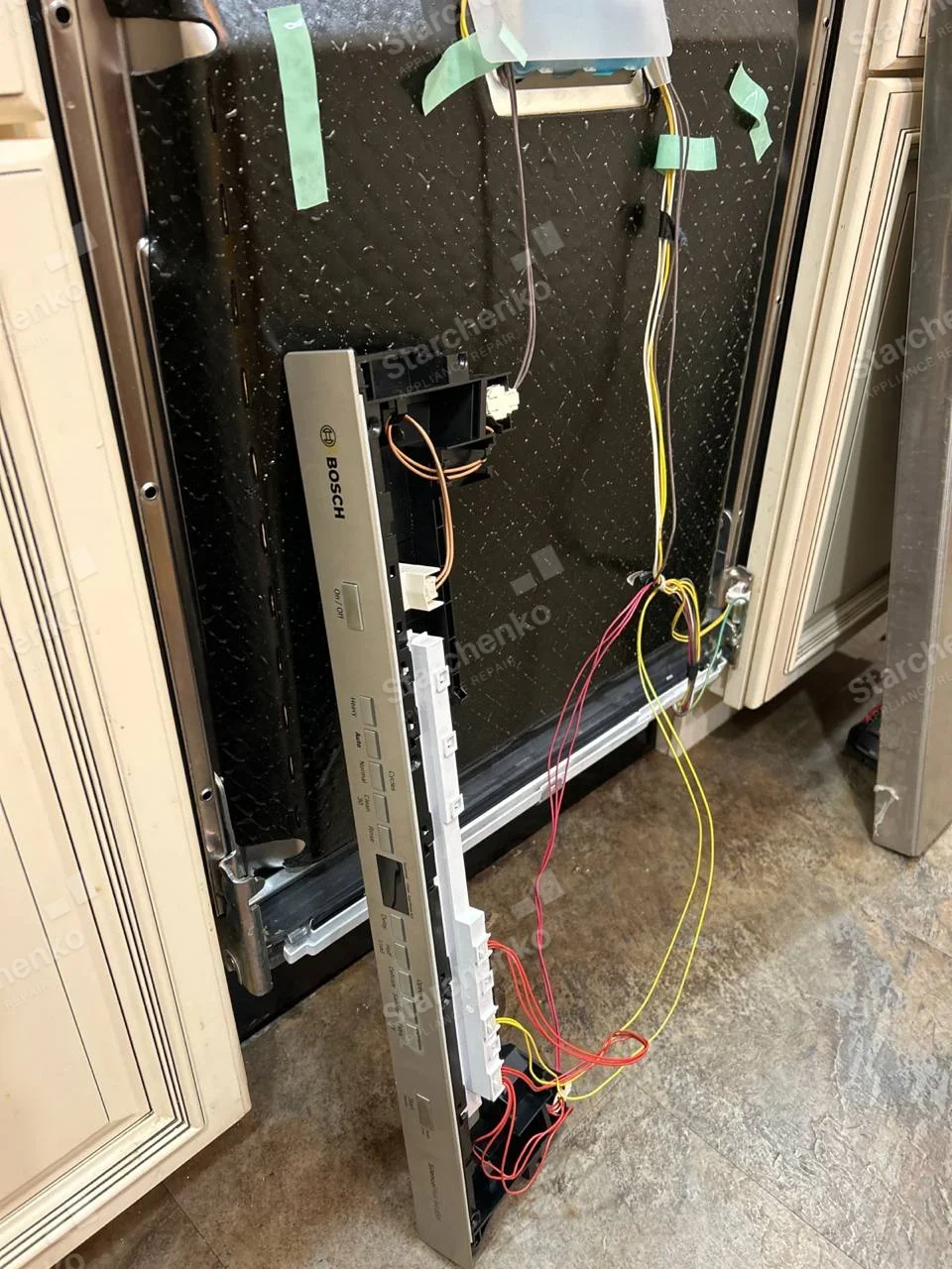BOSCH name printed on detached dishwasher door control strip, with wiring and door insulation exposed.