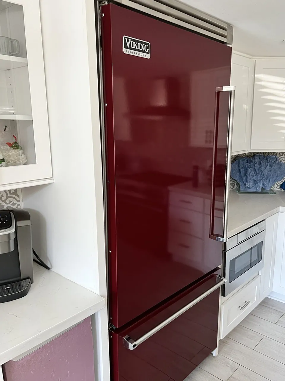 Burgundy Viking refrigerator with a bottom freezer in a white kitchen