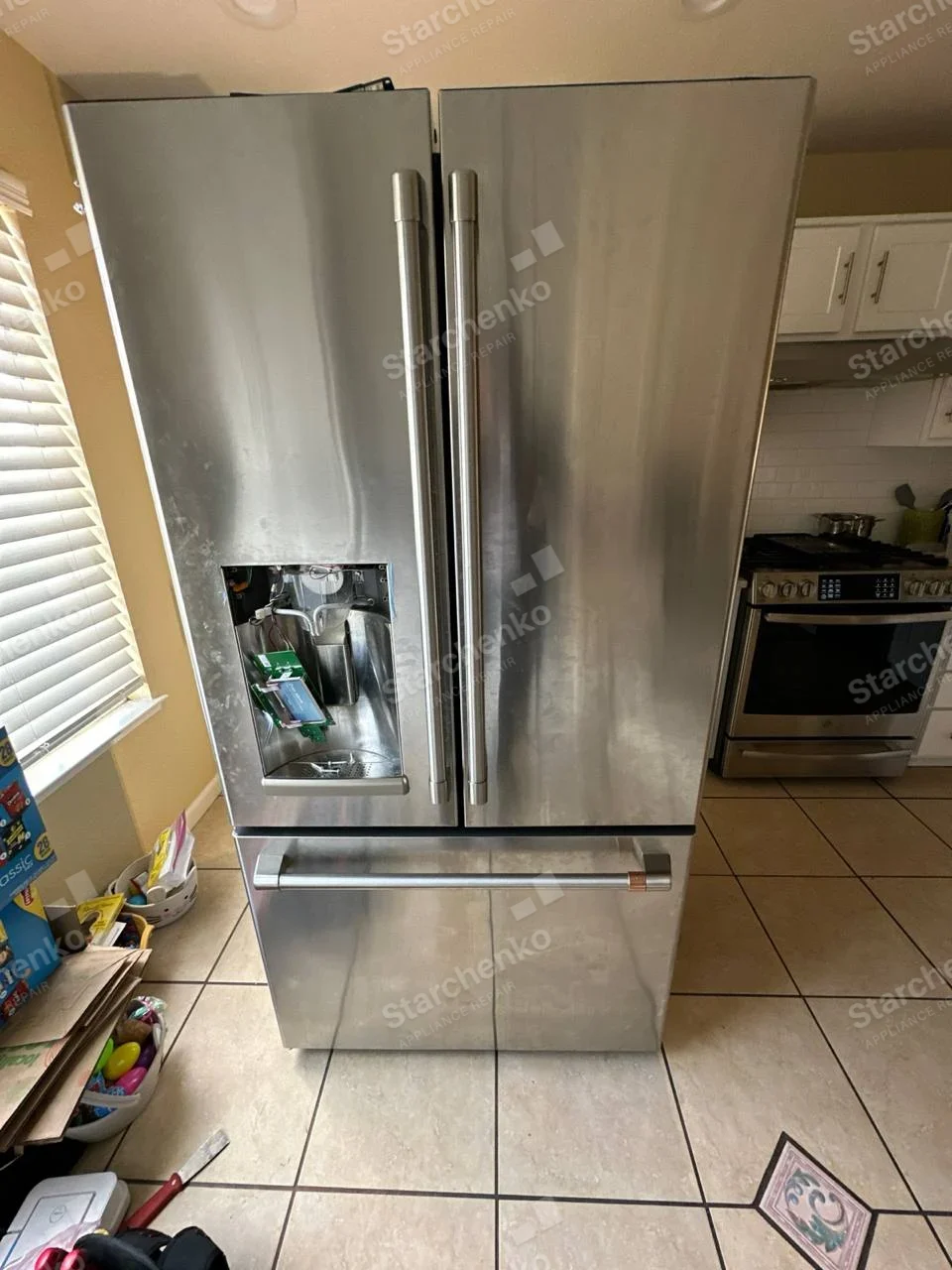 Frigidaire repair: French-door refrigerator with lower freezer drawer and left door dispenser trim removed to access circuit board.