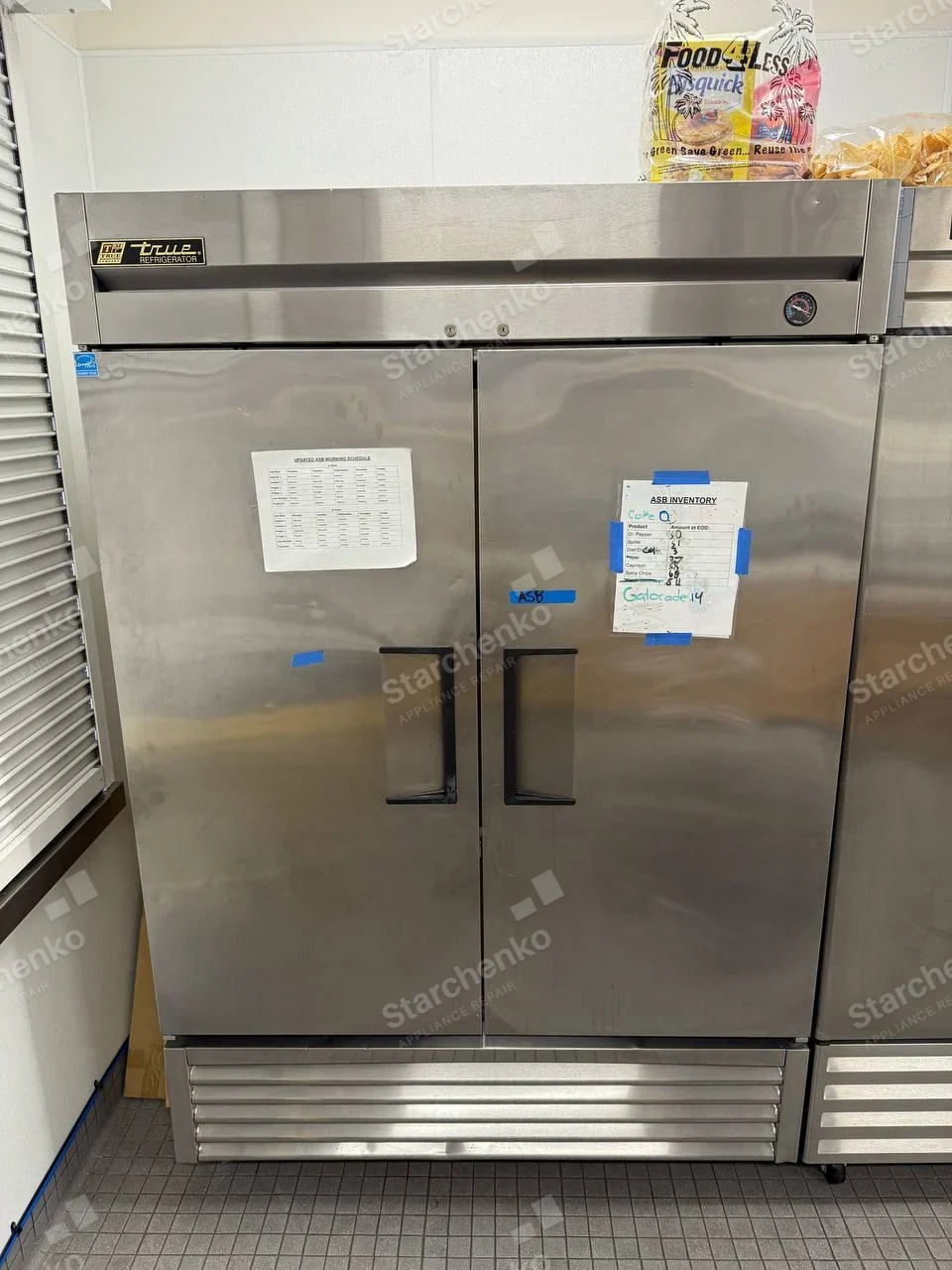 TRUE REFRIGERATOR badge on upper-left fascia of large two-door commercial upright refrigerator.