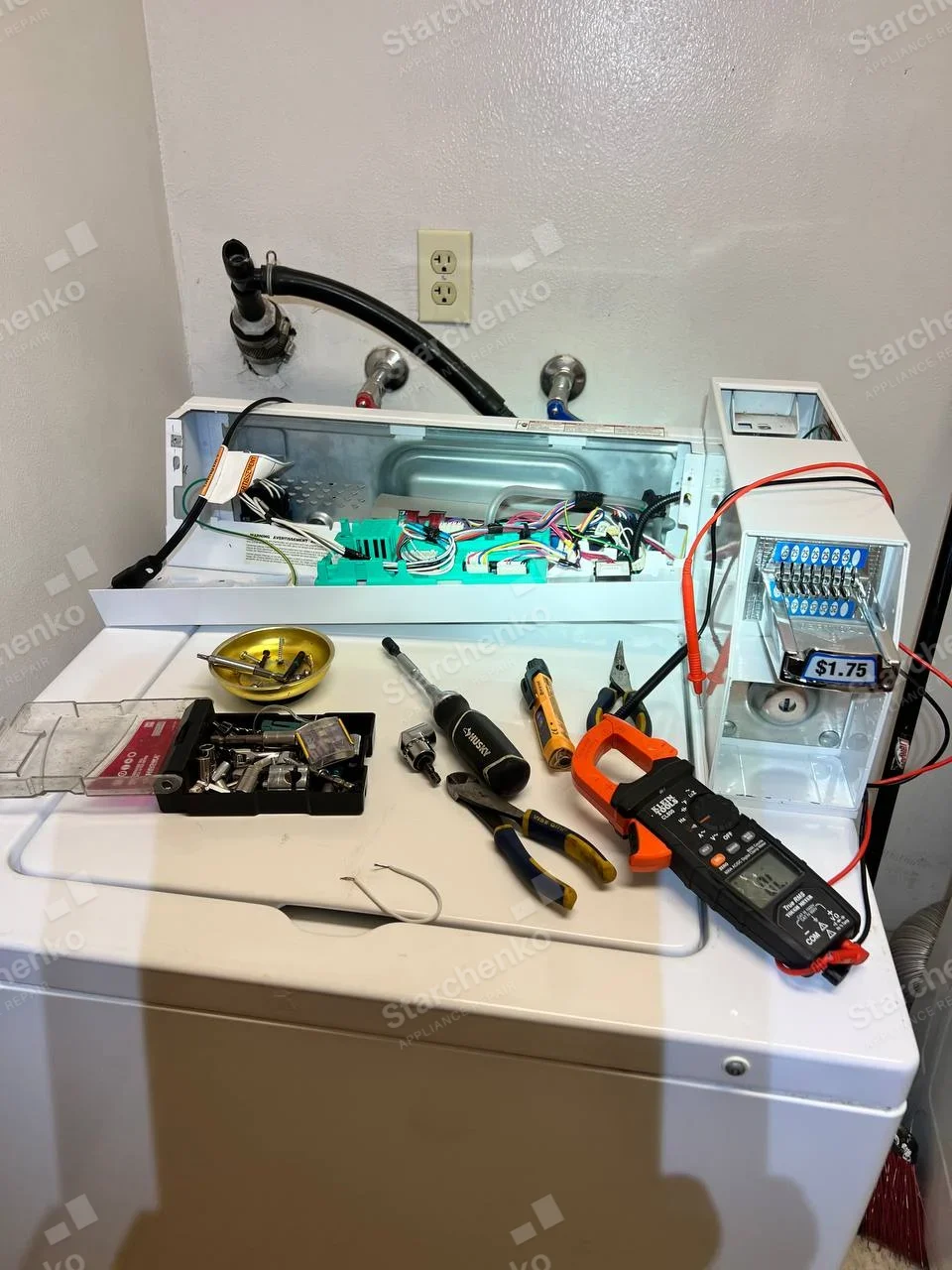 GE repair: Top-loading washer with $1.75 coin slide, rear control console open exposing wiring, meter probes at coin mechanism.