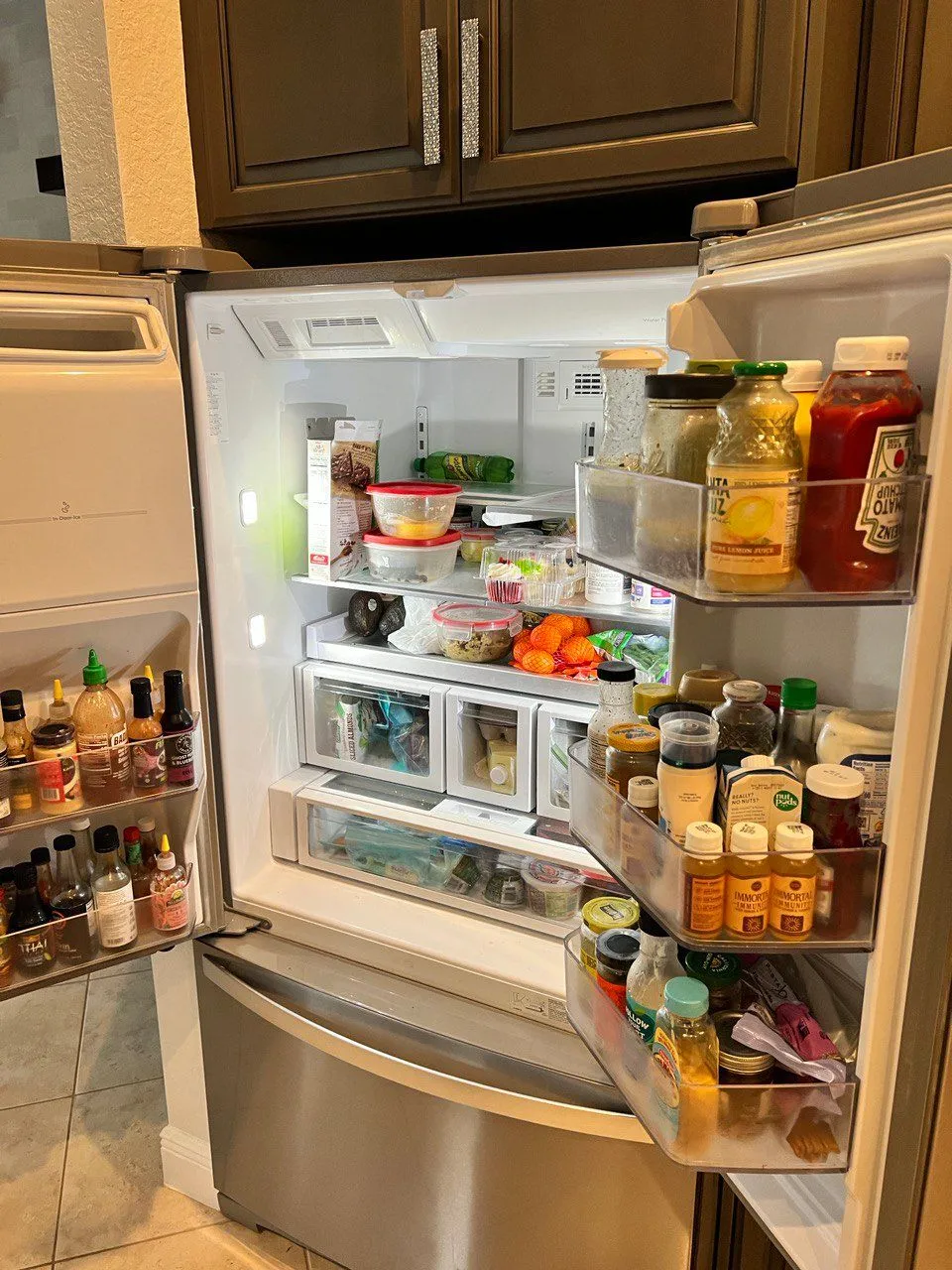 French-door refrigerator open with the shelves and door bins full