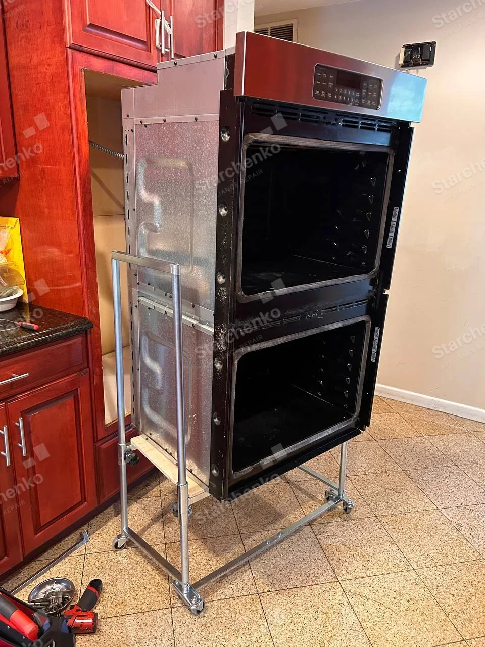 Samsung repair: Double wall oven on service frame with both front doors removed and oven cavities visible.