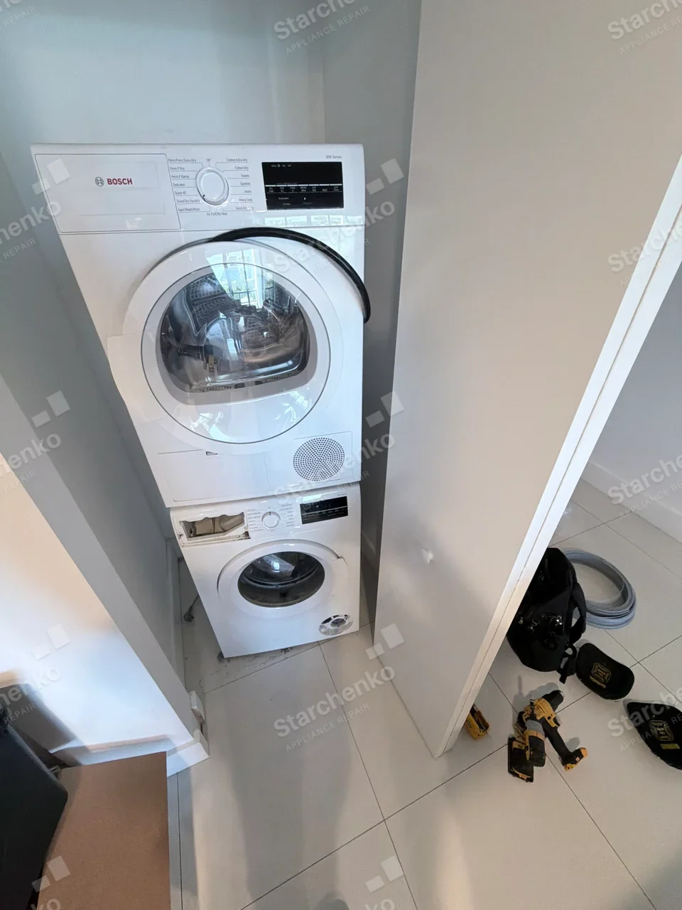 Kenmore repair: Stacked laundry pair, lower front-load washer detergent drawer is open, while BOSCH text belongs to the upper dryer.