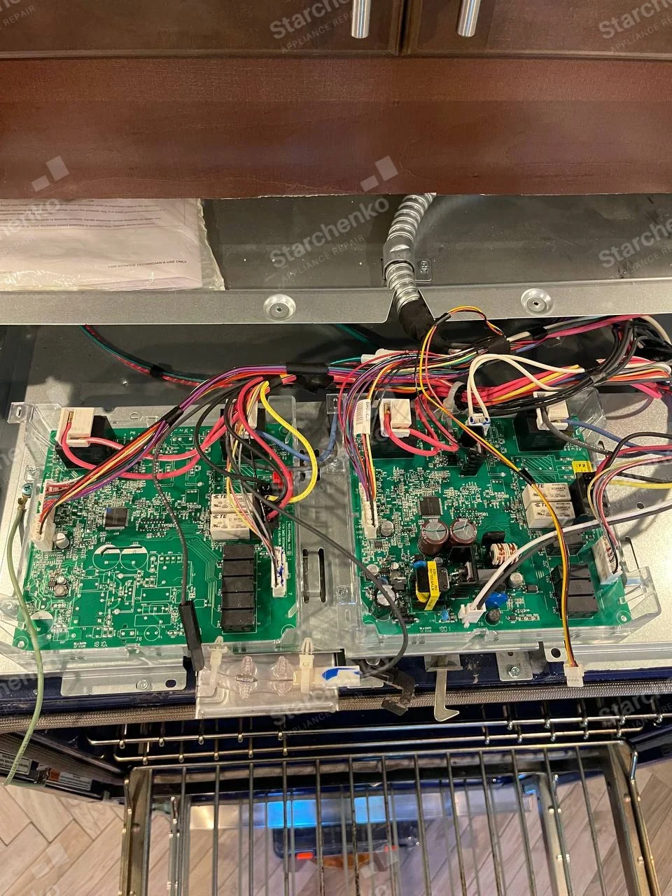 Samsung repair: Top of built-in oven with cover removed, exposing two electronic control boards and wiring above open oven cavity.