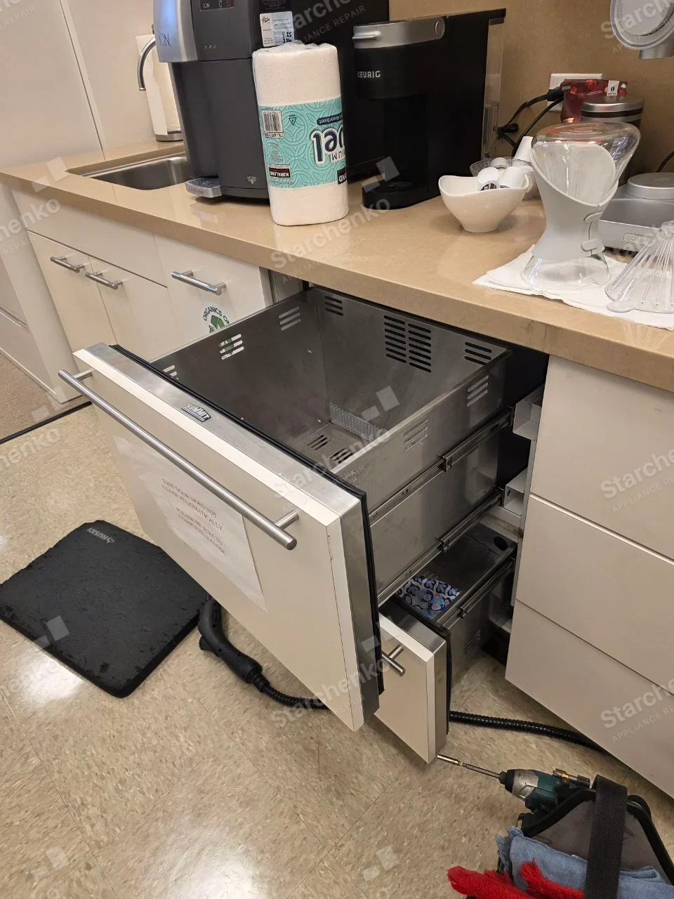 Hoshizaki repair: Open undercounter refrigerated drawer or cold-storage unit in workplace kitchenette, inner bin removed.