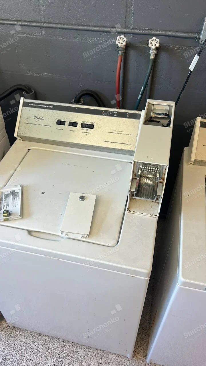 Whirlpool Commercial repair: Whirlpool logo and HEAVY DUTY COMMERCIAL WASHER lettering on top control console, coin mechanism opened.