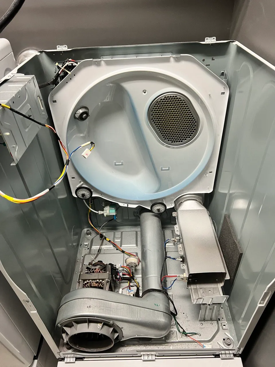 Dryer cabinet opened with the belt off and the motor exposed