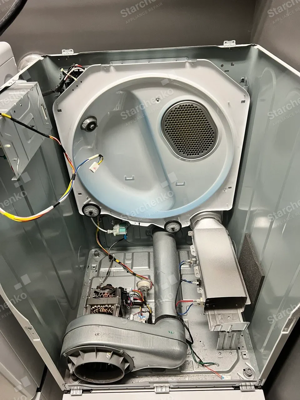 Dryer cabinet opened with the belt off and the motor exposed