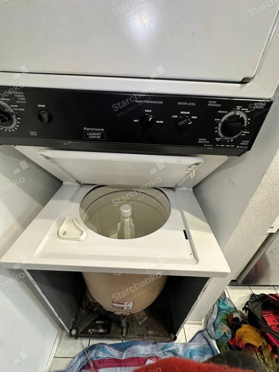 Kenmore Laundry Center lettering on shared control panel, lower washer top open and front removed exposing tub.