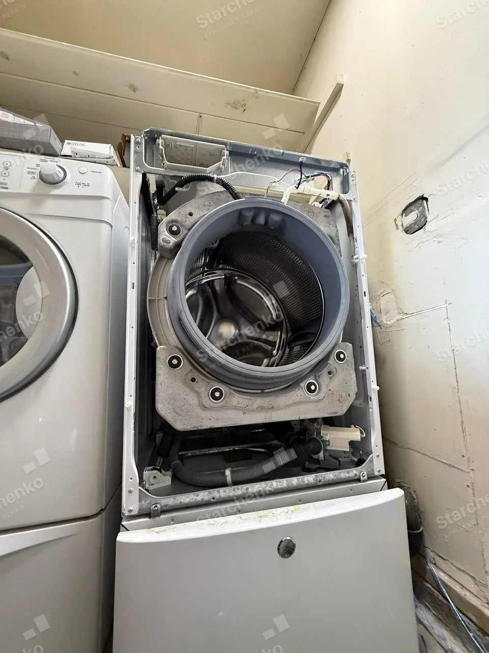 Kenmore repair: Front-load washer with its front panel removed.