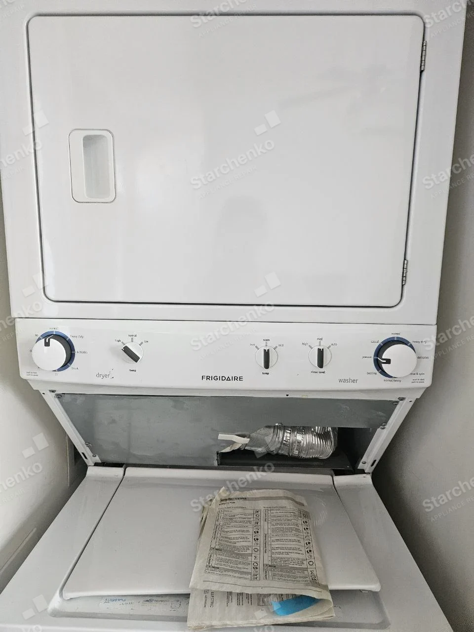 Frigidaire repair: One-piece stacked laundry center with upper dryer, lower washer and exposed dryer exhaust duct between sections.