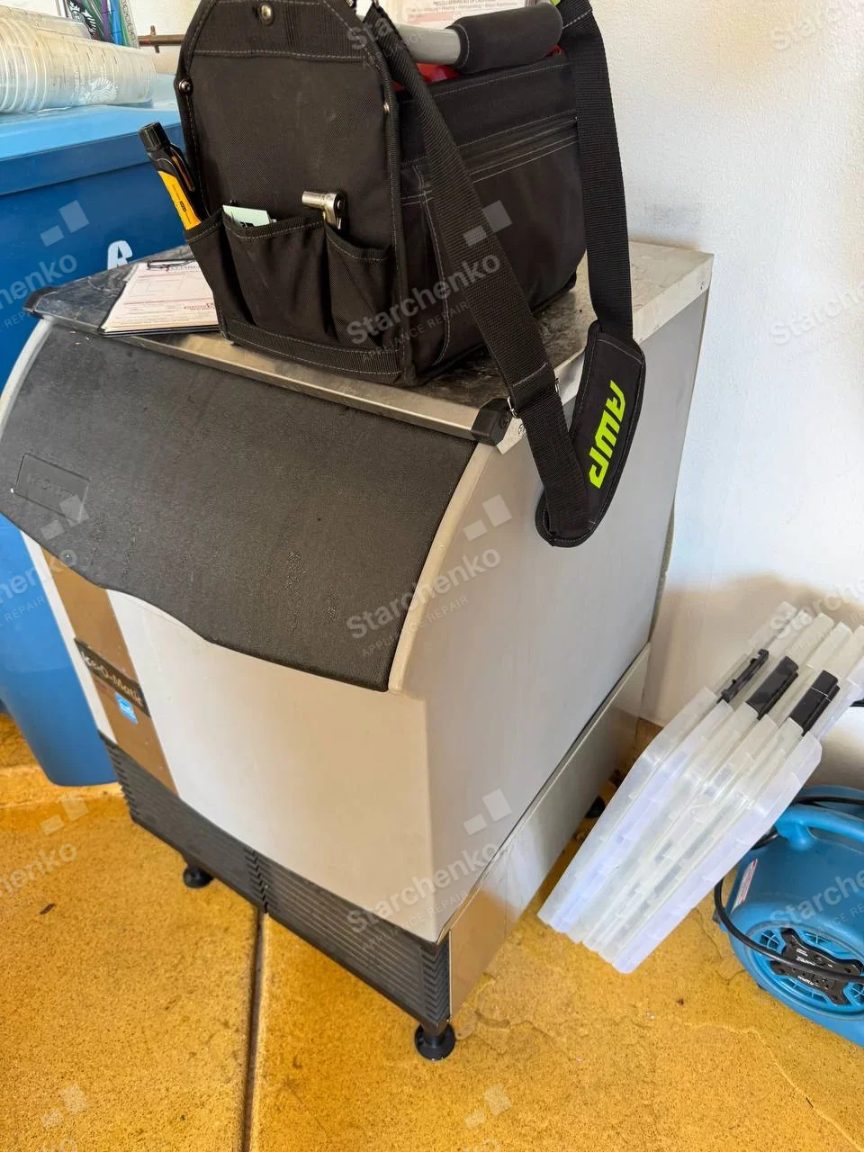 Kold-Draft repair: Freestanding ice machine with broad sloped bin lid and front ventilated service panel, tool bag on top.