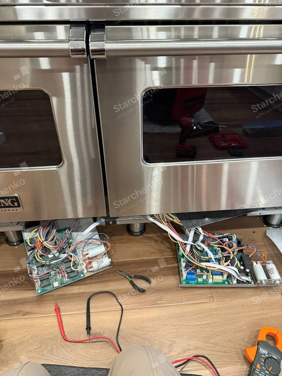 Partial Viking Professional badge visible on lower-left oven door of main double-oven range, electronic boards exposed below.
