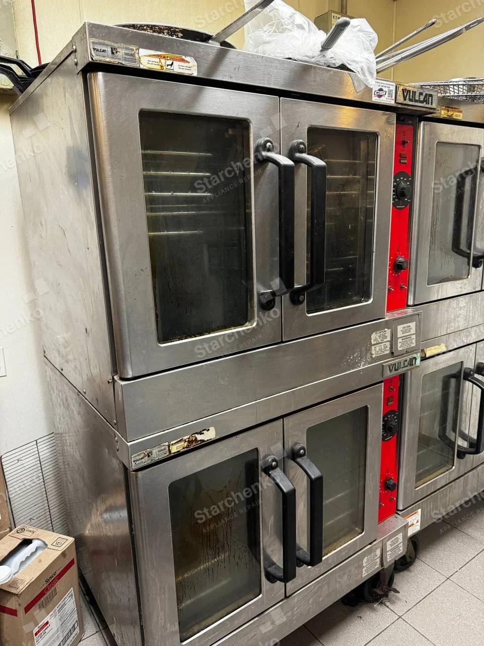 Vulcan repair: Large stacked commercial double-deck ovens with glass double doors and red control strips.