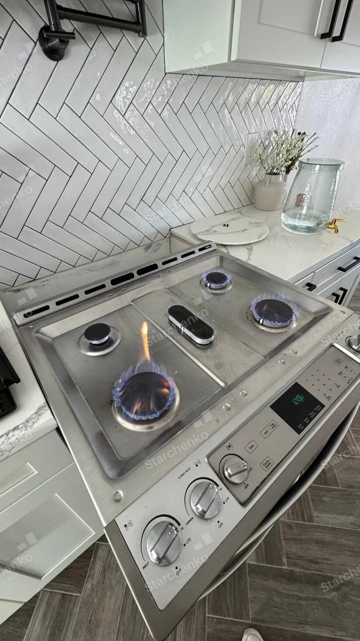 LG repair: Gas range burner flames tested on cooktop above front oven controls.