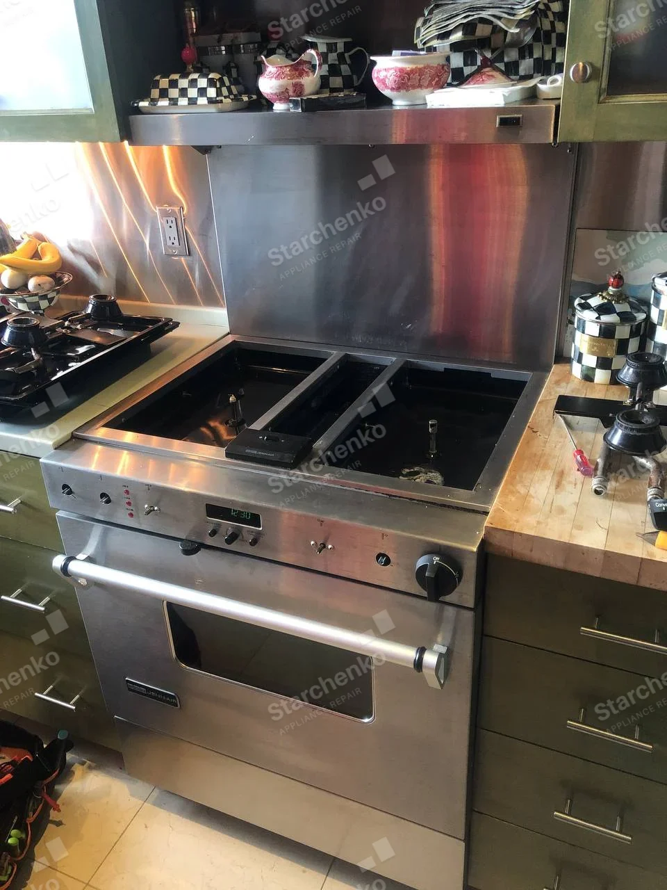 KitchenAid stainless gas range with cooktop burners and grates removed, cavities exposed.