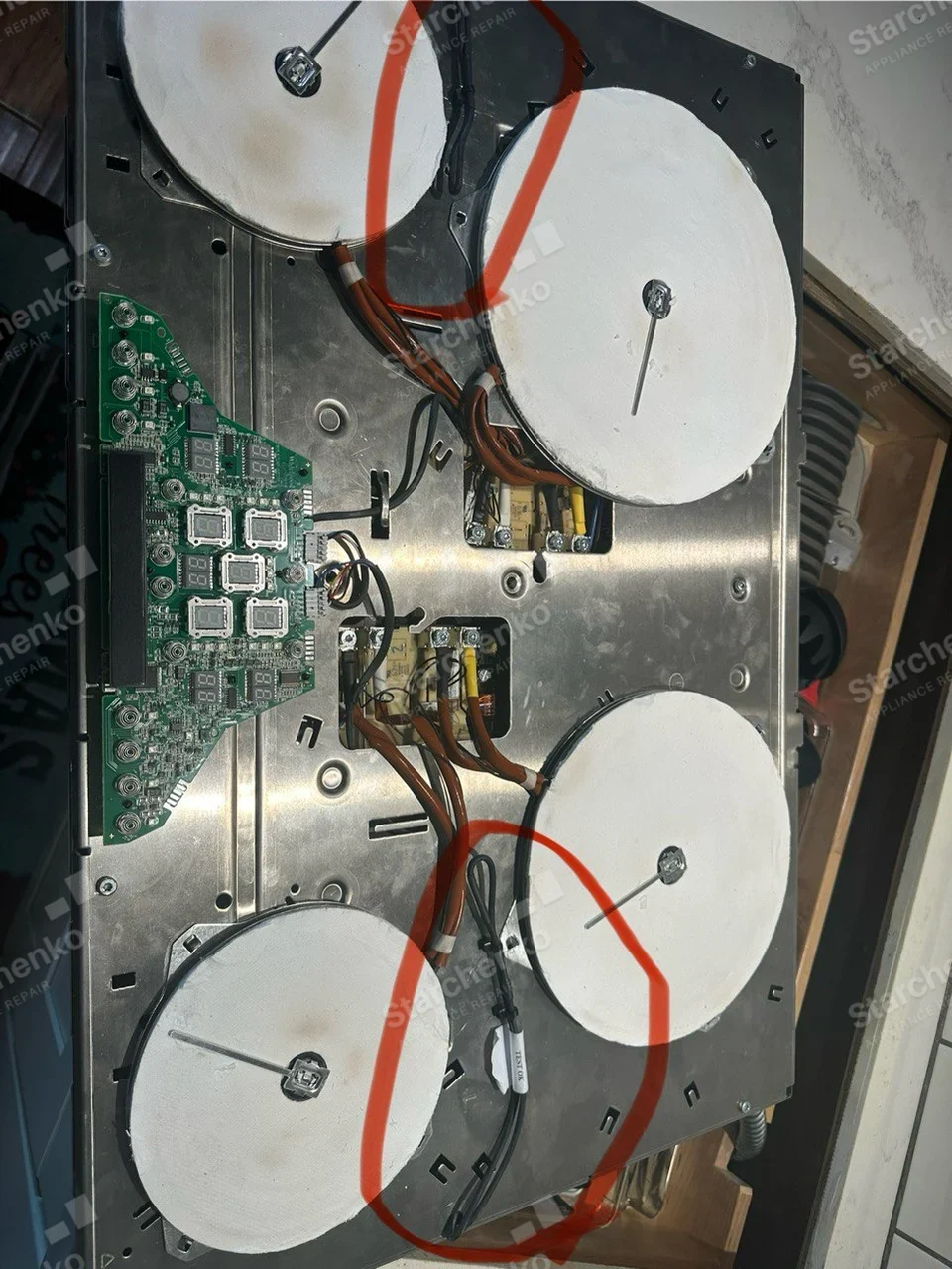 Underside of removed Thermador four-element electric cooktop with wiring and control board exposed.