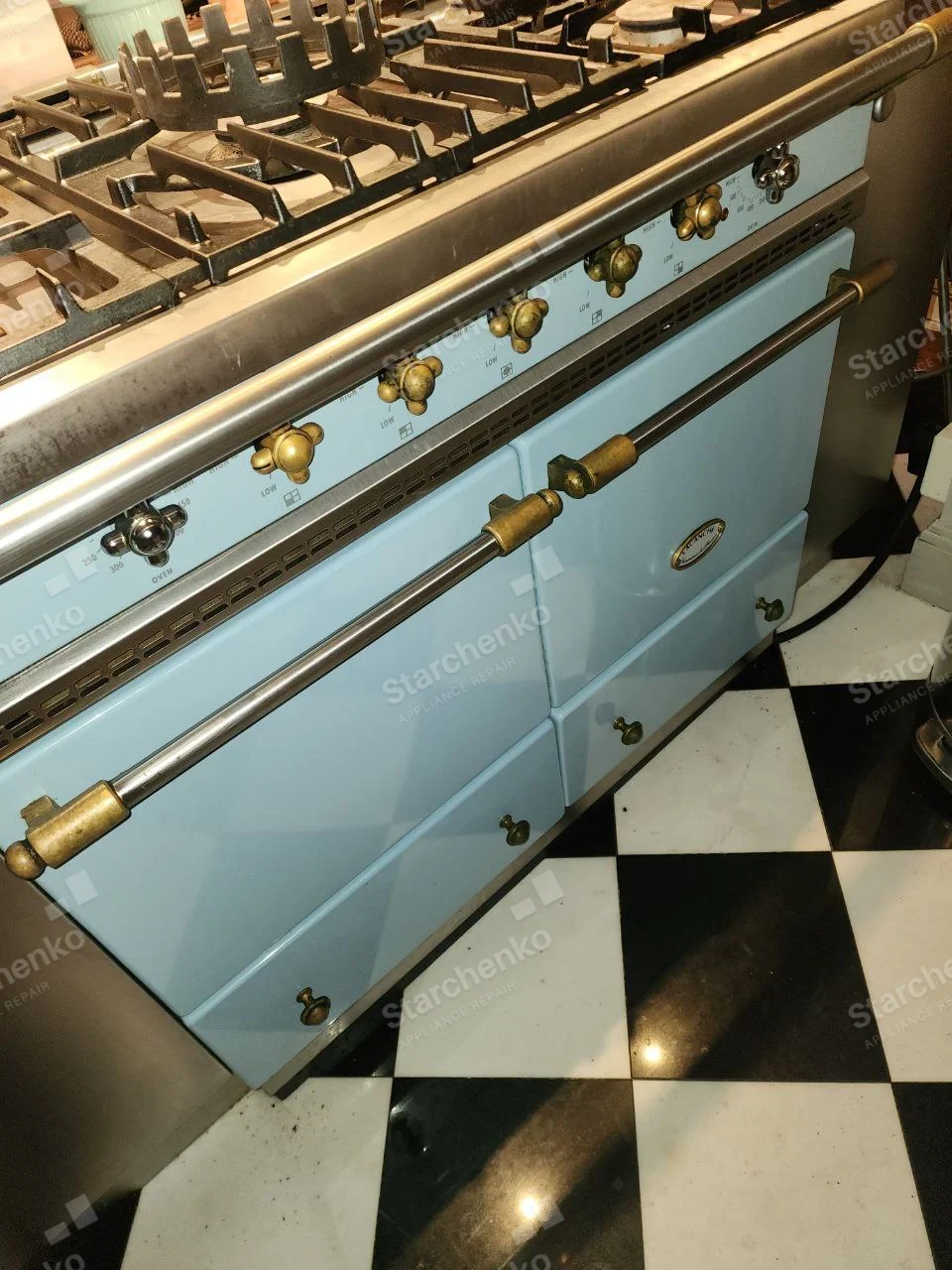 Bertazzoni repair: Blue enamel wide gas range with brass controls and two oven doors, oval badge on right door illegible.