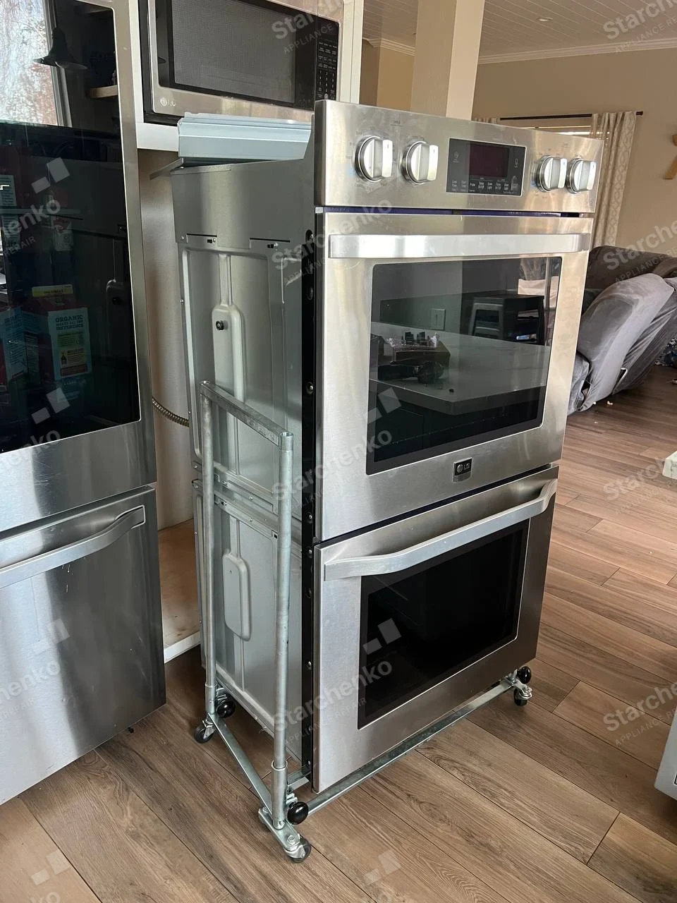 LG badge on upper oven door of double wall-oven assembly removed from wall on service cart.