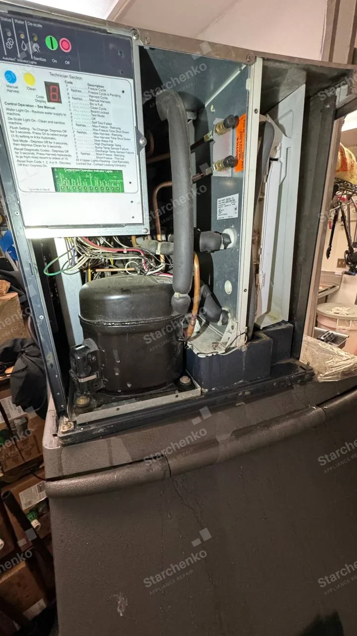 Kold-Draft repair: Ice machine upper housing open with compressor, refrigerant lines and service/diagnostic control panel, large ice bin below.