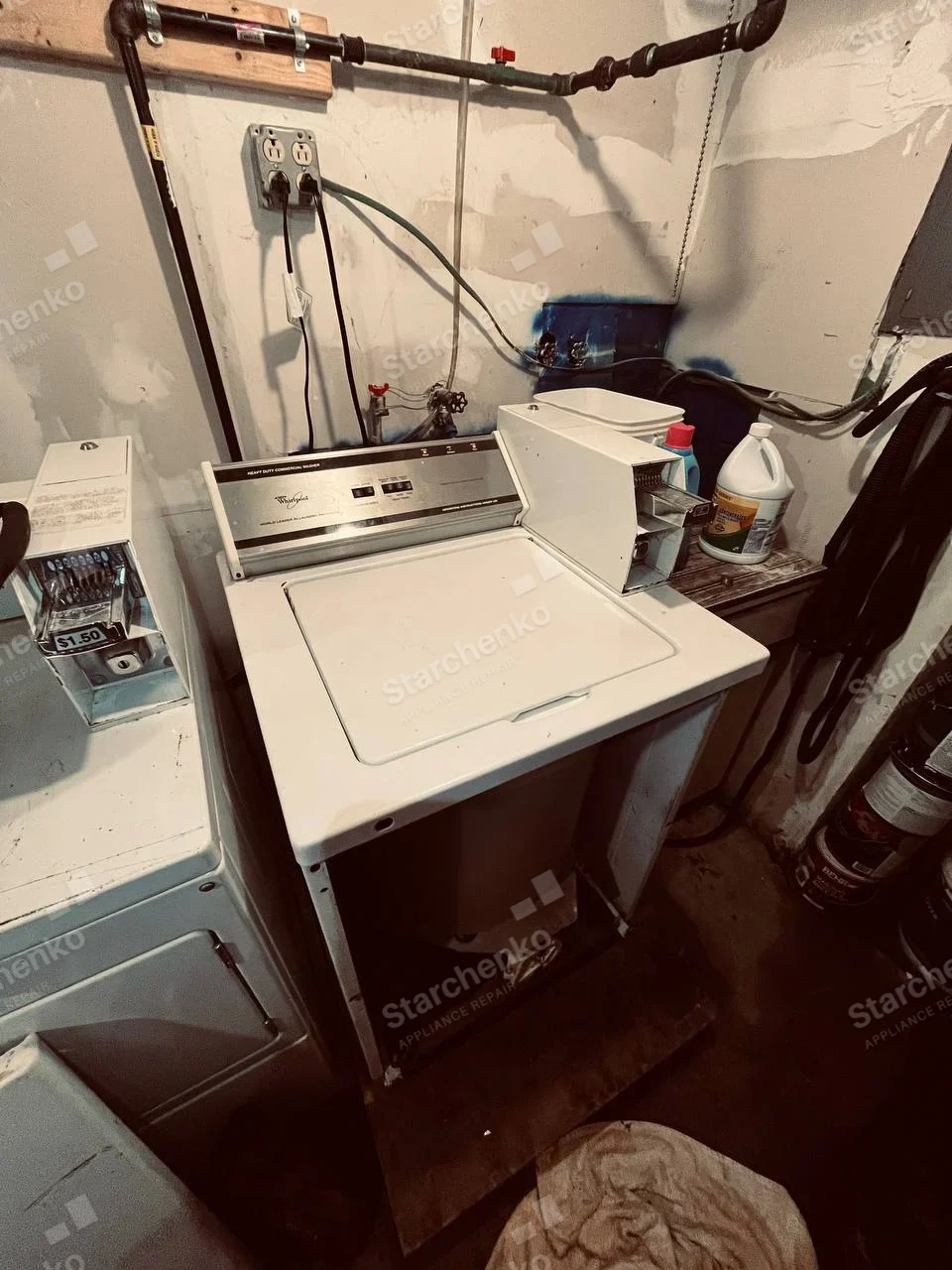 Whirlpool Commercial repair: Commercial coin-operated top-load washer with its front cabinet removed and coin slide housing open.