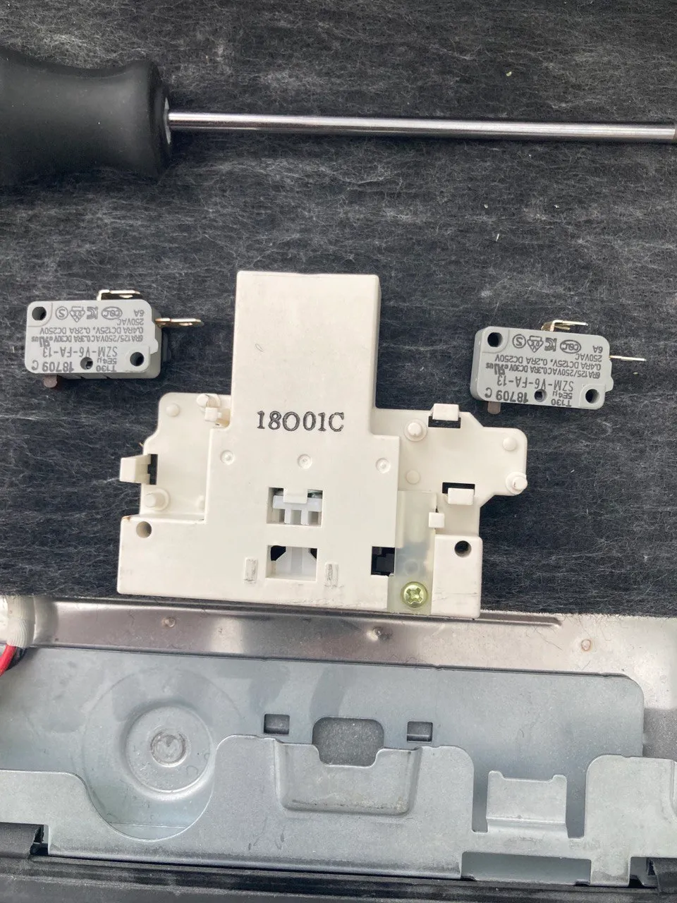 Dishwasher door latch assembly with its microswitches removed for testing