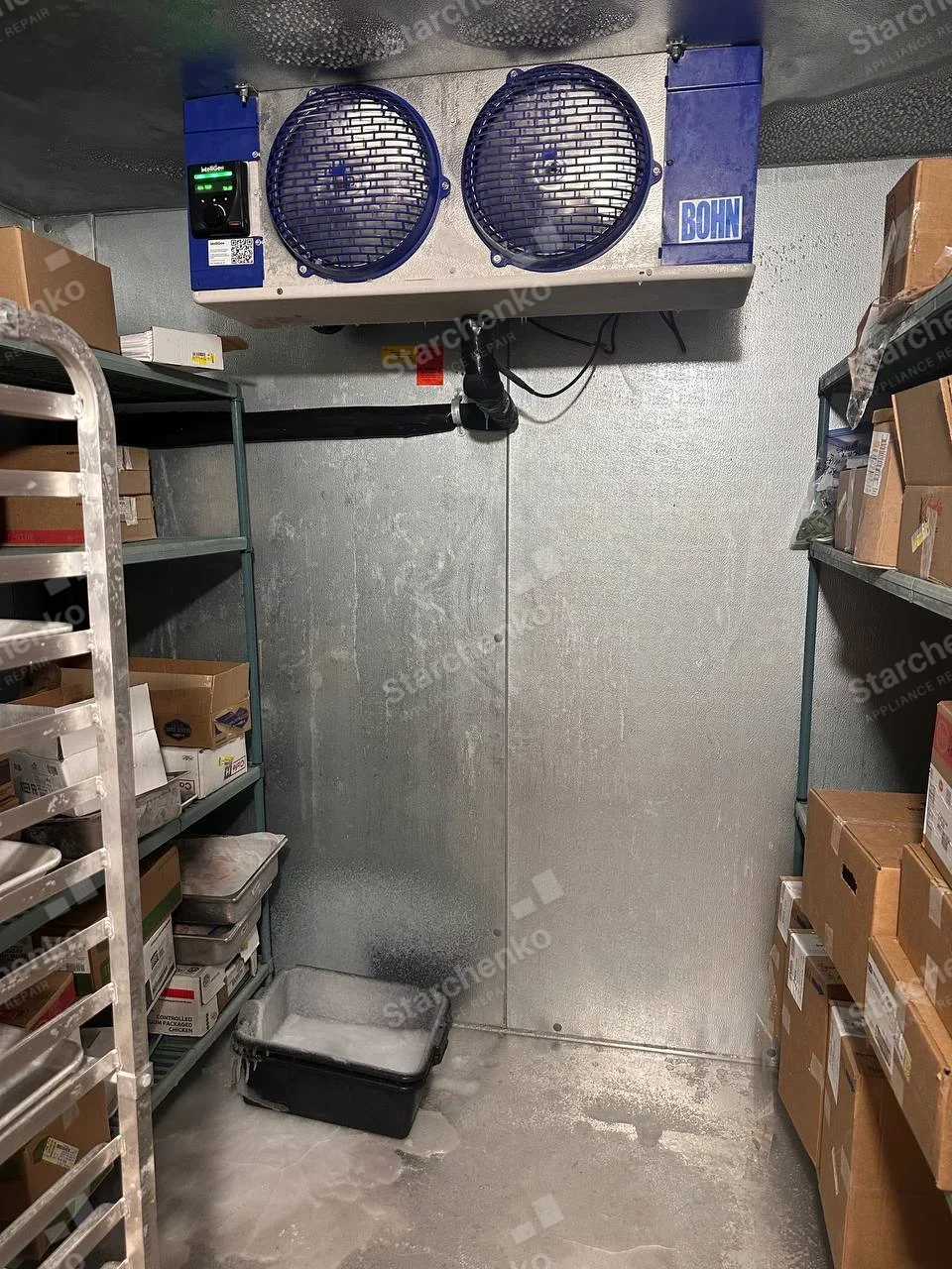 Nor-Lake repair: Walk-in cold room interior with ceiling-mounted dual-fan evaporator and storage shelves.