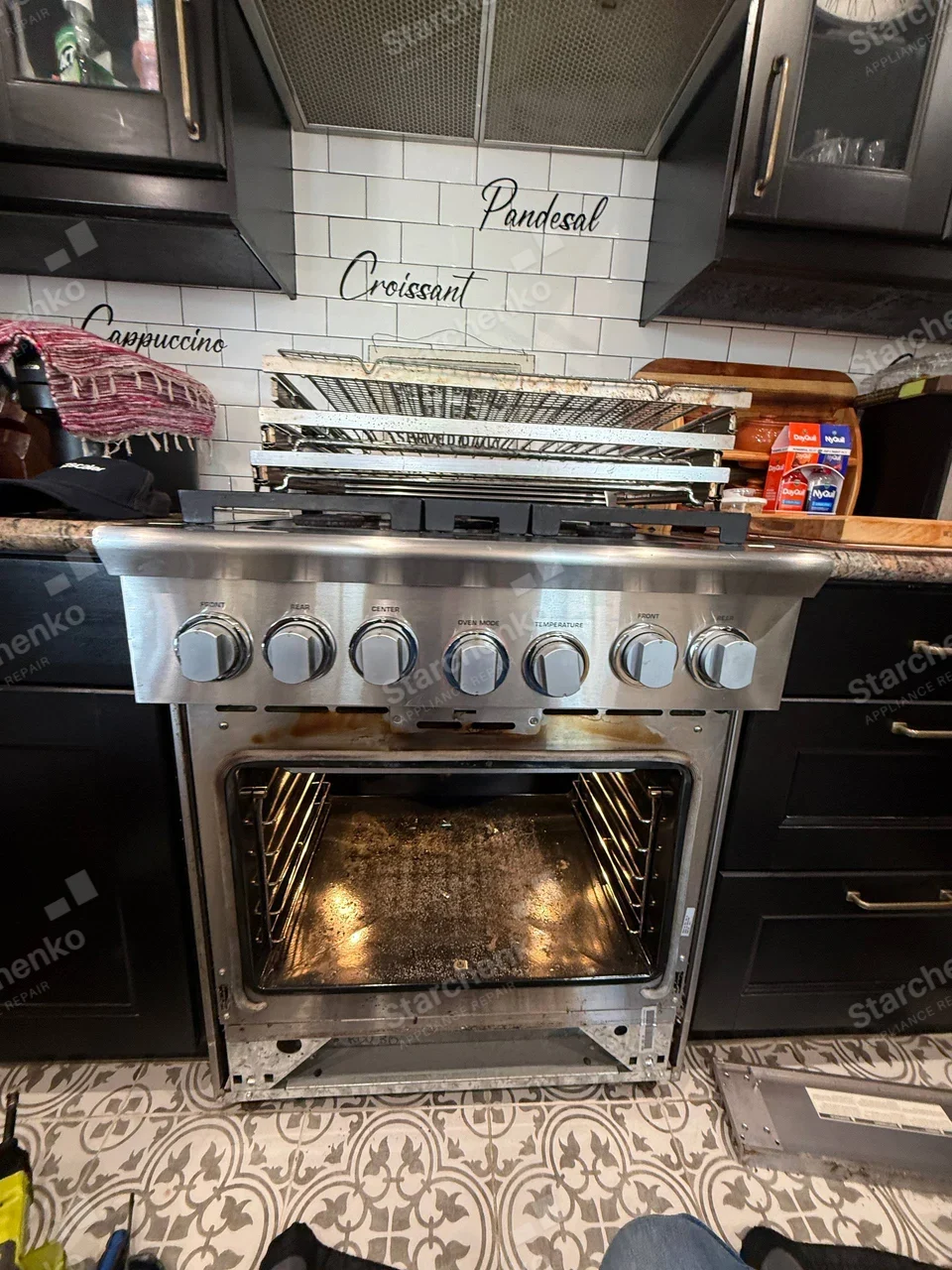 LG repair: Gas cooktop and oven in one freestanding range, oven open and lower fascia removed, no readable manufacturer badge.
