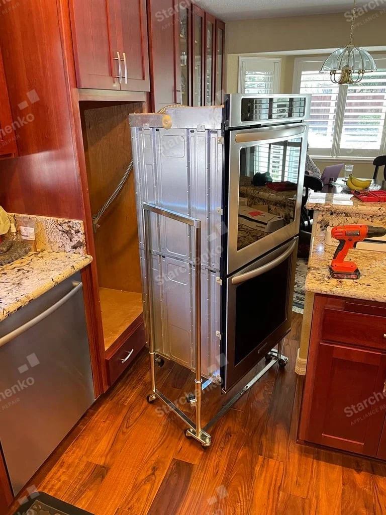 Samsung repair: Stacked microwave and wall oven removed from kitchen cabinet on a wheeled dolly.