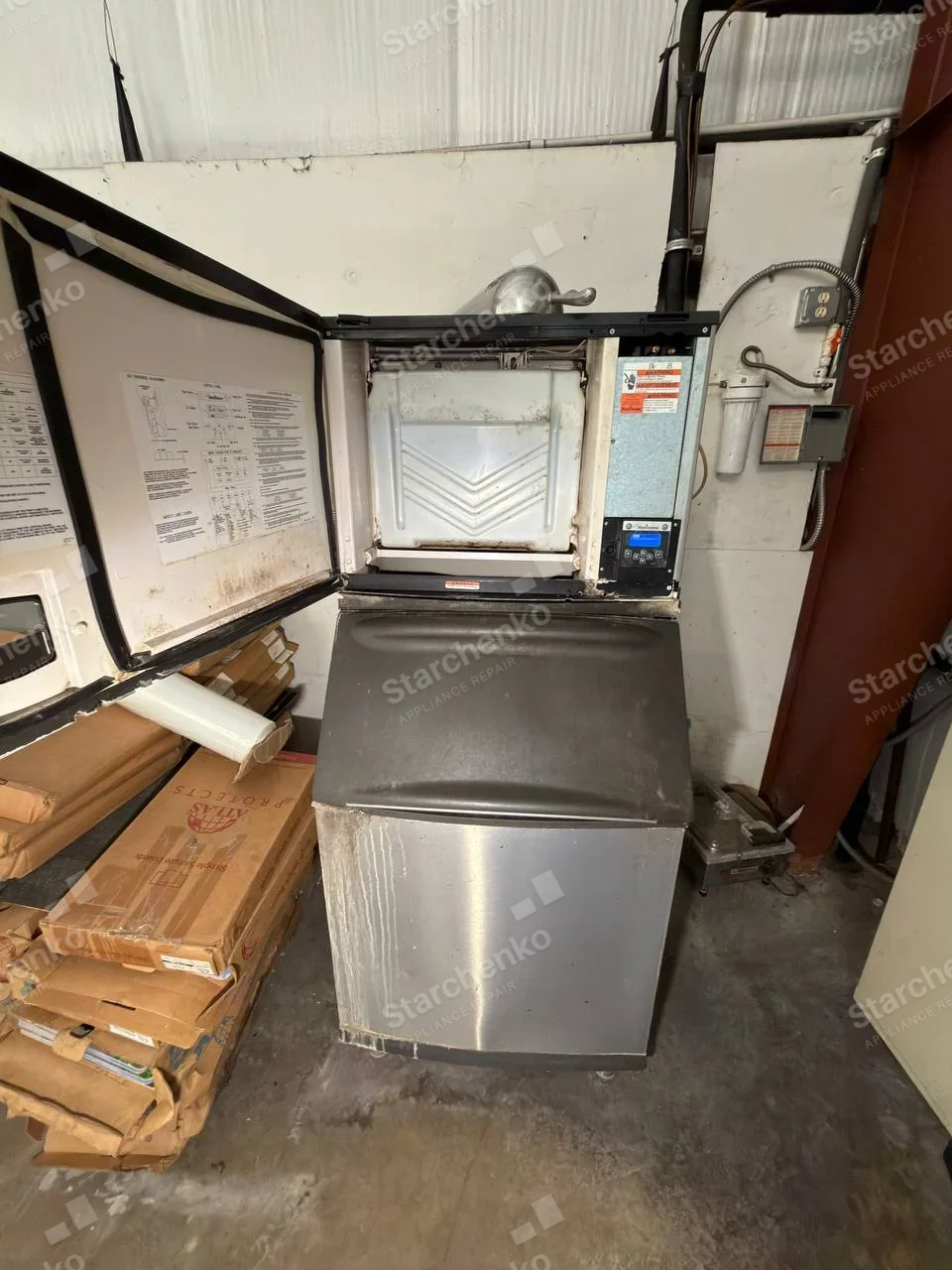 Kold-Draft repair: Large freestanding ice machine with upper ice-making compartment exposed and lower storage bin.