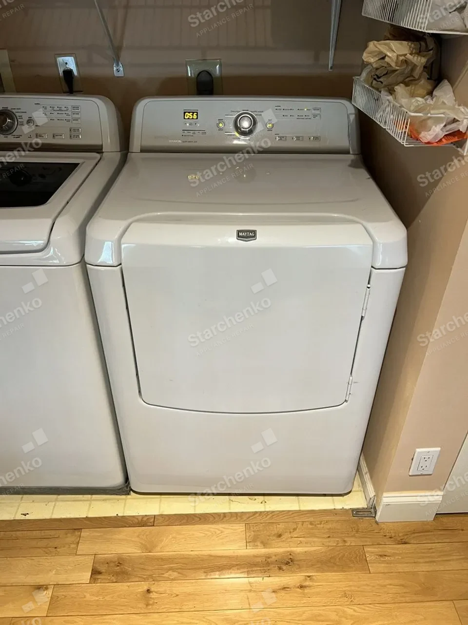 White Maytag dryer next to a top-load washer in a laundry closet