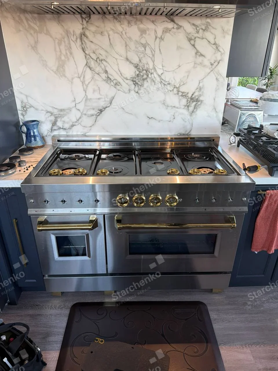 Kenmore repair: Two-door gas range with brass knobs and burner caps removed.