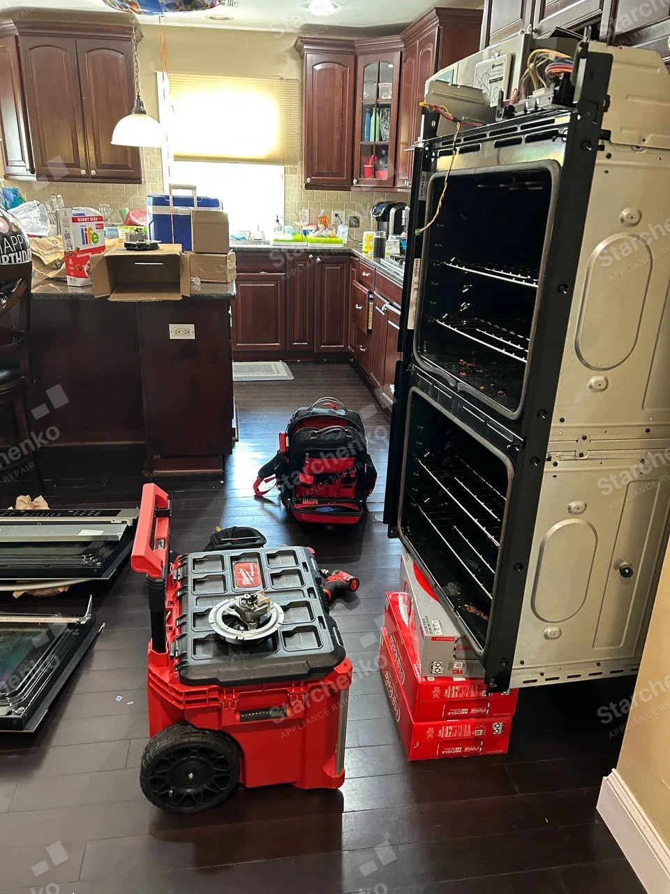 Samsung repair: Double wall oven removed, doors and control fascia detached, two cavity interiors and wiring visible.