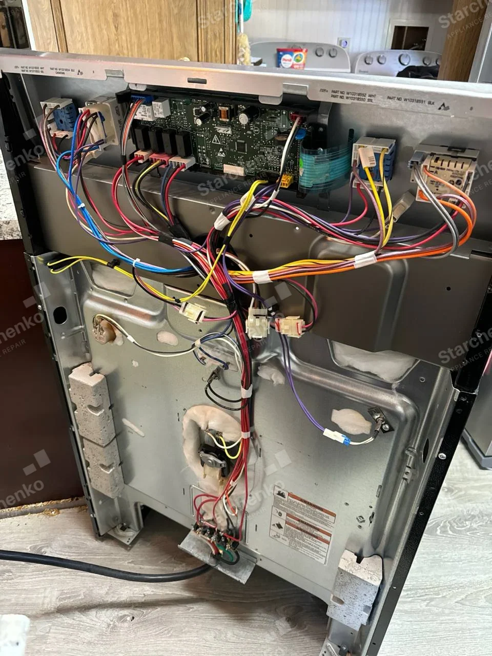 Rear casing of built-in Samsung oven removed, exposing control board at top, wiring and insulated oven cavity.