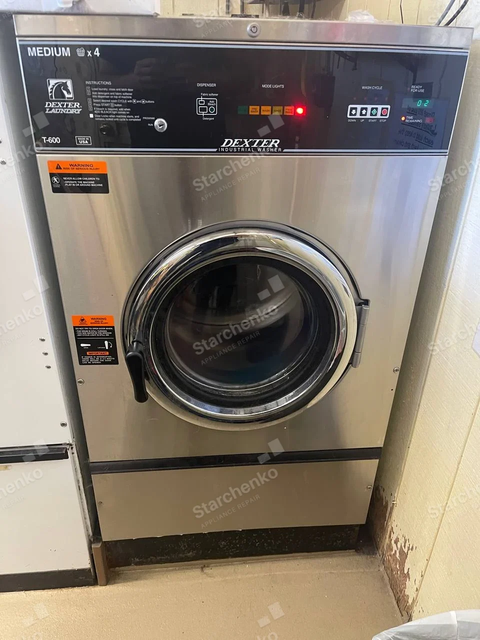 Dexter repair: Large commercial front-load industrial washer with illuminated cycle display.