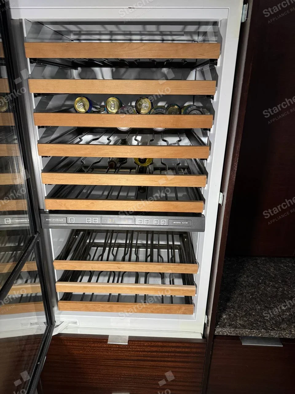 Marvel repair: Open wine storage cabinet with wooden bottle racks and control panel, maker text is not confidently legible.