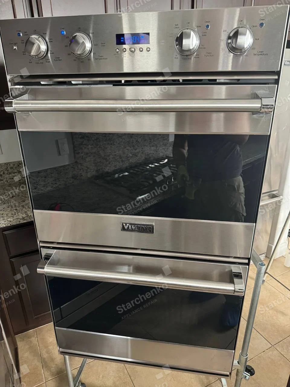 Viking double wall oven pulled out on a wheeled service stand with controls powered.