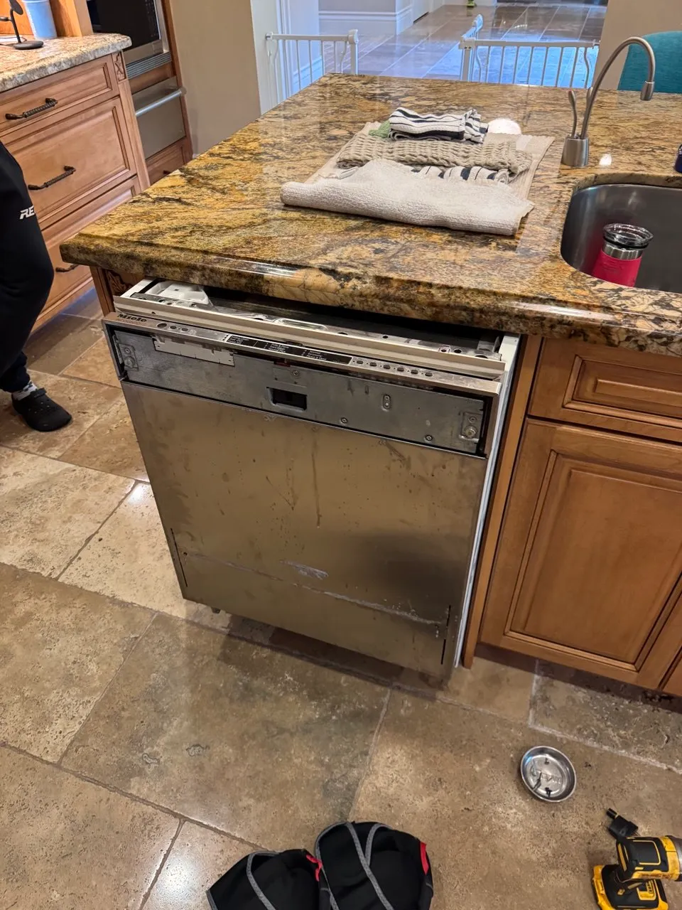 Panel-ready Miele dishwasher pulled out of its cabinet with the door hardware removed