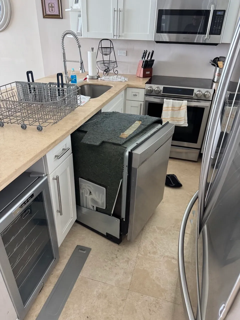 Dishwasher pulled from under the counter with its insulation blanket still on