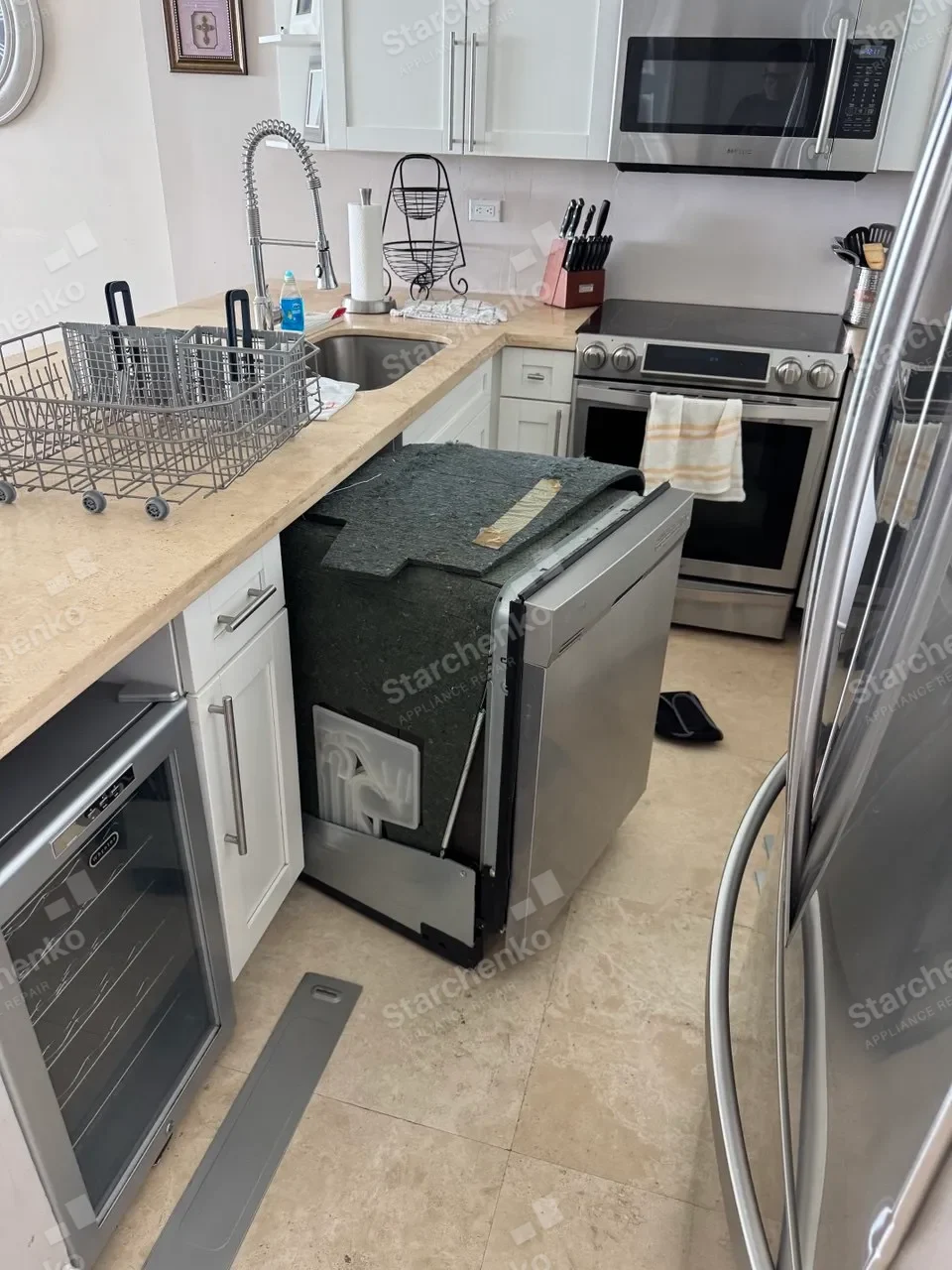 Whirlpool dishwasher pulled from under the counter with its insulation blanket still on
