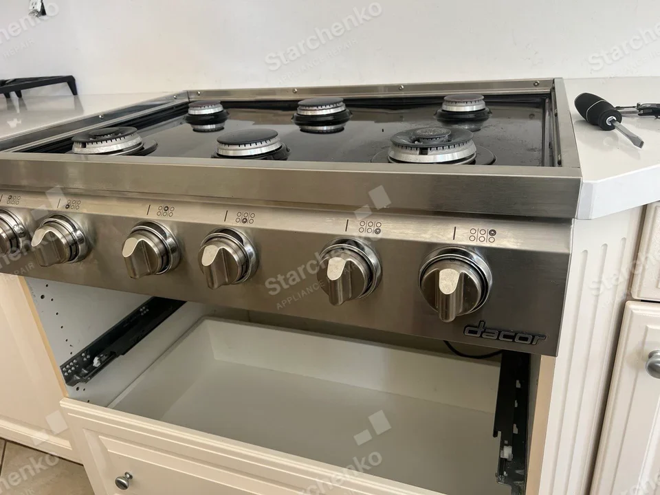 Dacor six-burner gas cooktop with front controls and empty cabinet opening below.