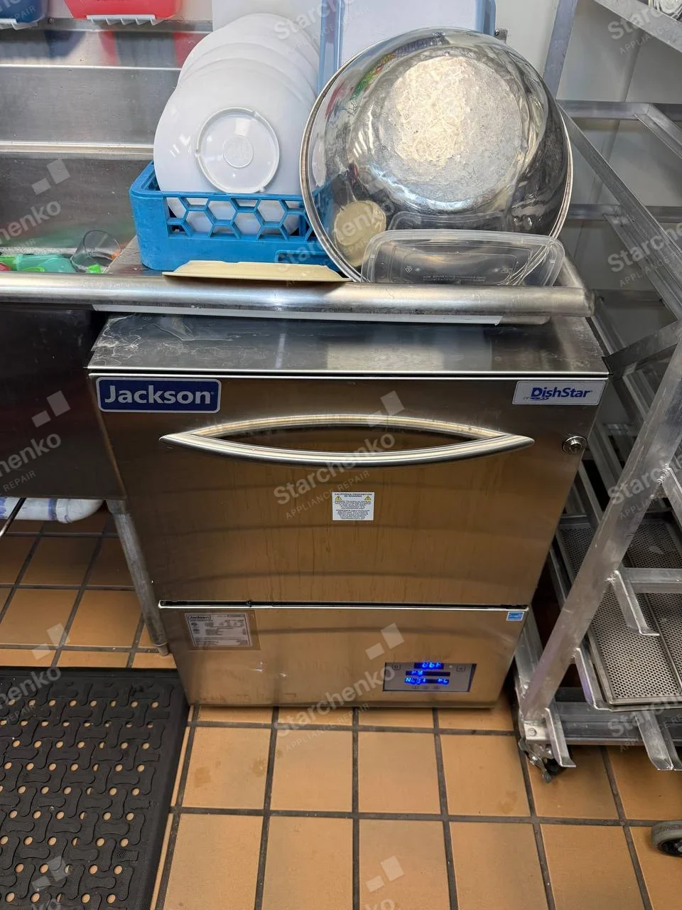 Jackson badge on front upper-left of commercial DishStar undercounter dishwasher, dish rack above.
