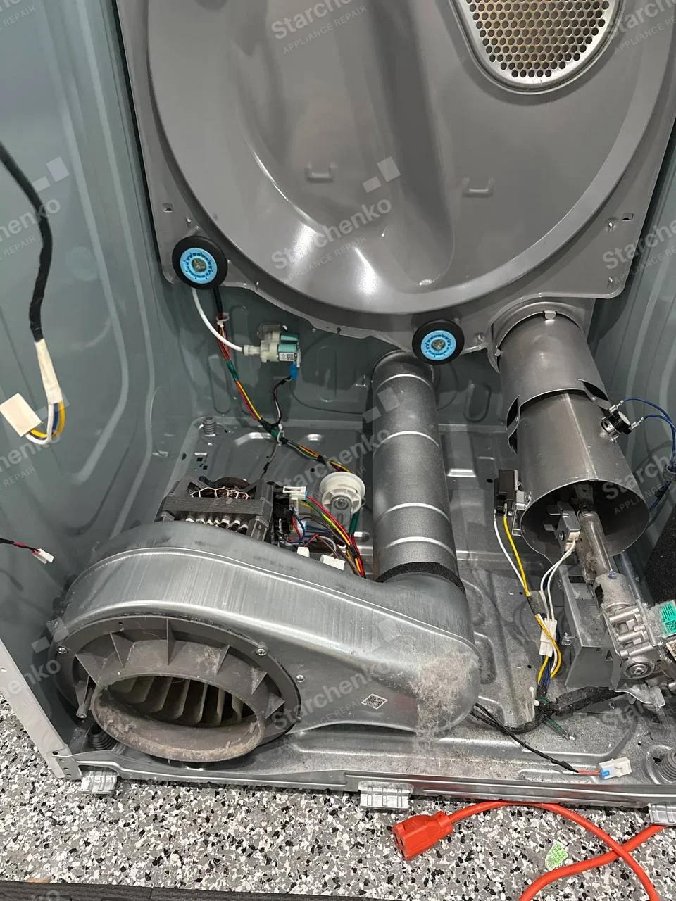 Kenmore dryer repair: Open dryer rear with drum rollers, blower and heater duct, no appliance badge.