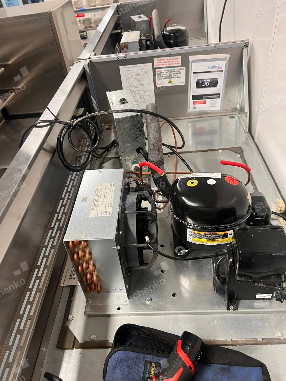 Open top refrigeration deck of Continental freezer showing compressor, fan and tubing.