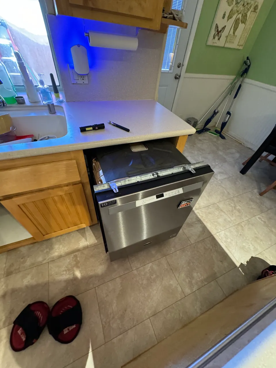 Stainless LG dishwasher pulled forward with the toe panel off