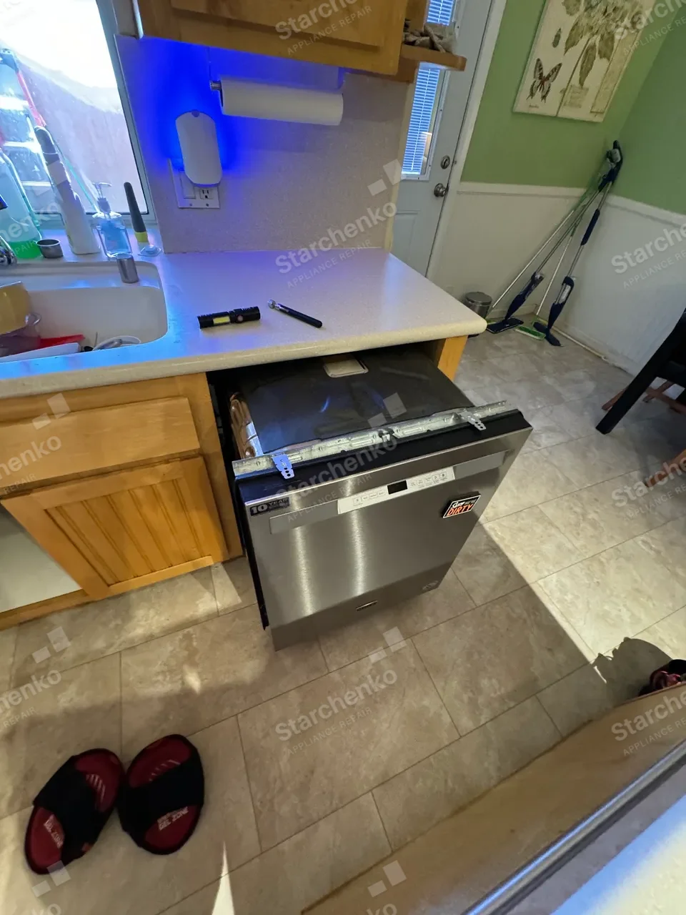 Stainless Maytag dishwasher pulled forward with the toe panel off